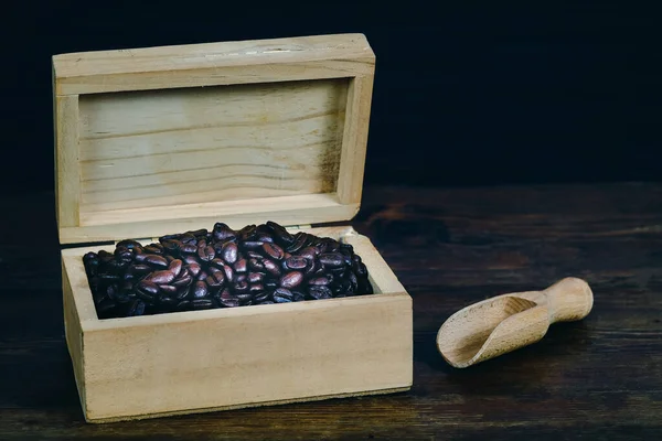 Grain de café dans une boîte en bois sur fond de vieux bois . — Photo