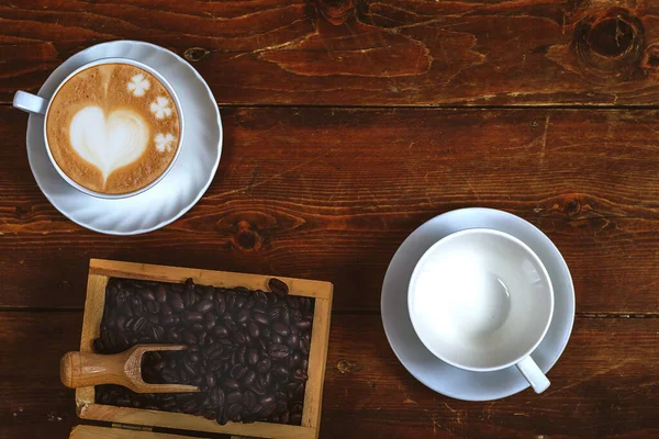 Coffee bean in wood box with late art coffee on old wood backgro — Stock Photo, Image