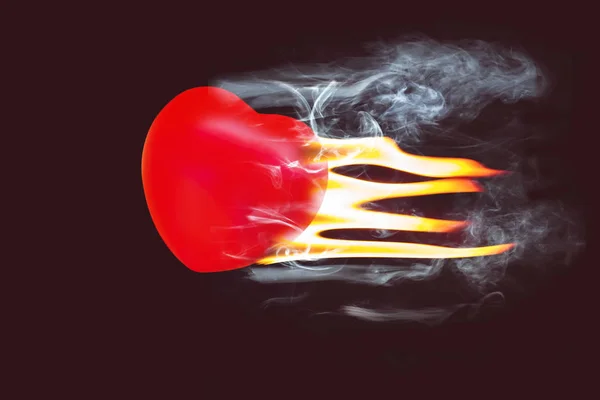 Rode hart bal vliegen met vuur en rook op donkere achtergrond. — Stockfoto