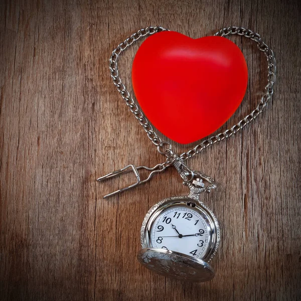 Red heart ball with vintage pocket watch on wood backround. — Stock Photo, Image