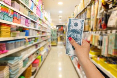 Hand hold bank note at shopping store background.