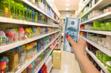 Hand hold bank note at shopping store background.