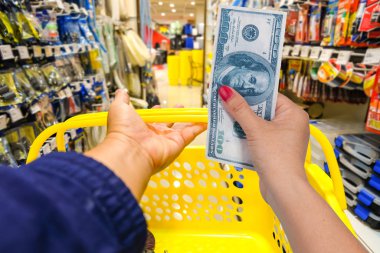 Hand hold bank note at shopping store background.
