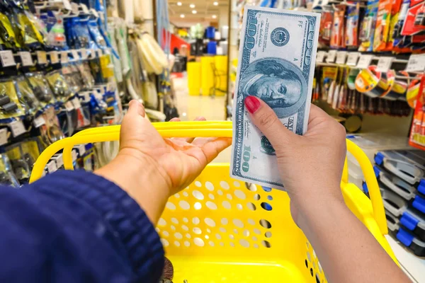 Hand hold bank note at shopping store background.