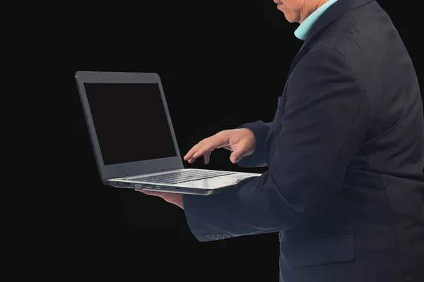 商人拿着笔记本电脑在黑色背景下工作 — 图库照片