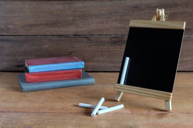 Çalışma masasında beyaz tebeşirle duran küçük bir karatahta. .