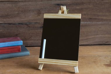 Çalışma masasında beyaz tebeşirle duran küçük bir karatahta. .