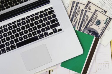Kitap bankası ve banknotu olan dizüstü bilgisayarın en üst görünümü.