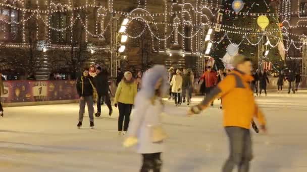 Ludzie jeżdżą na lodowisku na głównym placu Rosji. Plac Czerwony w Moskwie — Wideo stockowe