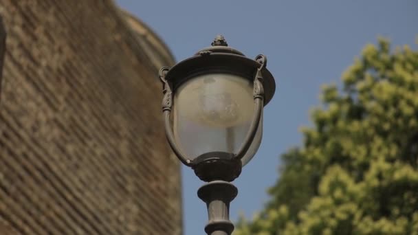 Panormama antik bir taş kulenin duvarlarında bir sokak lambasıyla. — Stok video