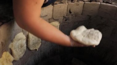 Doğu ekmekleri tandırda pişirilir. Fırının duvarındaki hamuru kapat.