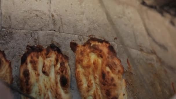 Oosters brood wordt in tandoor gekookt. Sluit het deeg op de muren van de oven — Stockvideo