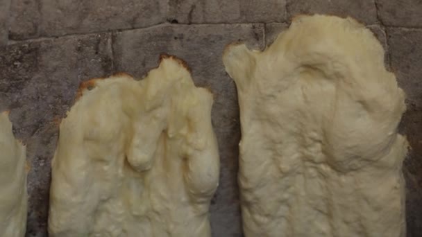 Orientalisches Brot wird in Tandoor gekocht. den Teig an den Wänden des Backofens schließen — Stockvideo