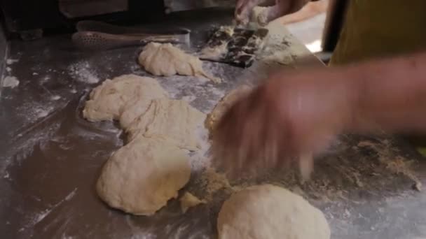 Egy idős, férjes asszony kezei tésztát gyúrnak. Darabokra szedi a tésztát. — Stock videók