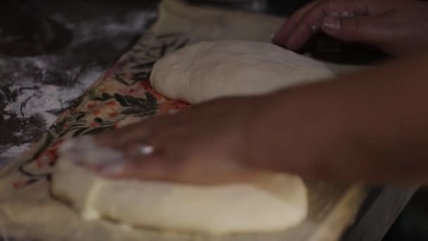 Les mains d'une femme mariée âgée pétrissent la pâte. Elle roule la pâte en morceaux — Video