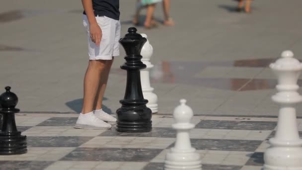 Lidé hrají šachy na centrálním náměstí. Přesouvají obrovské šachové figurky. — Stock video