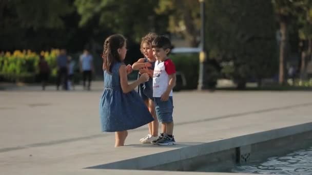 Plac miejski z fontanną, letni słoneczny dzień, dzieci bawią się na placu — Wideo stockowe