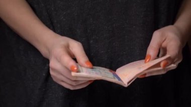 Seyahat için pasaportunu karıştıran bir kız. Çok sayıda vizesi var. Sadece eller.