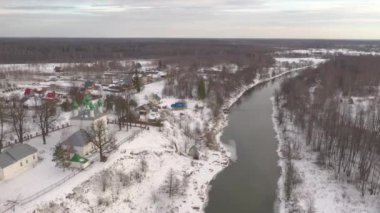 Bir Rus köyünün havadan görünüşü. Ormanın, evlerin, kilisenin üzerindeki panorama.