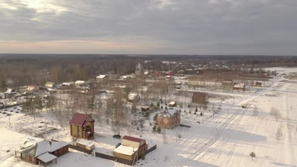 Luchtfoto van een Russisch dorp. Panorama over het bos, huizen, kerk. — Stockvideo