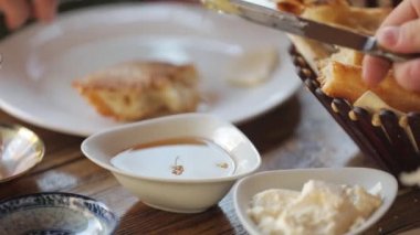 Küçük bardakta bal. Bir adam bıçakla toplar ve tortilla üzerine bal sürer.