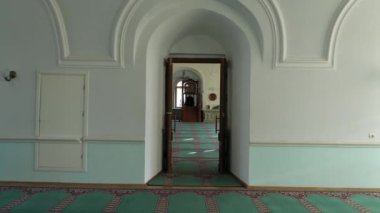 A lonely unidentifiable man prays in mosque. A small empty mosque. Muslim people