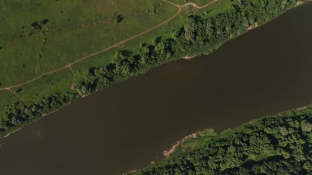 Vue aérienne d'une large rivière, d'un pré verdoyant, d'une petite forêt et d'une route de campagne . — Video