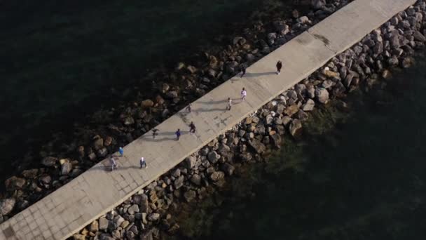 Vista superior de los niños entrenando al aire libre en el muelle junto al mar aéreo 4K — Vídeo de stock