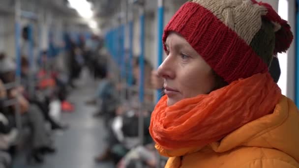 Uma mulher de roupas de inverno cavalga em um vagão de trem e segura o corrimão — Vídeo de Stock