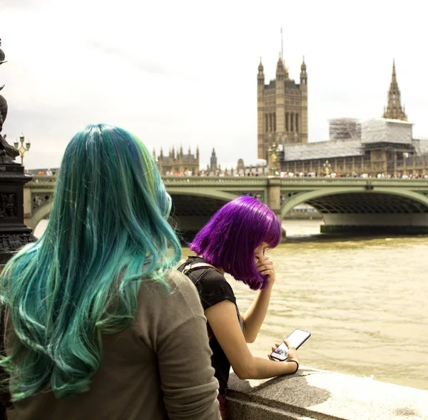 Ragazze non identificate con eleganti capelli colorati guardare attraverso la distanza presso la banca del Tamigi e Westminster Abbey, Big Ben. Inghilterra . — Foto Stock