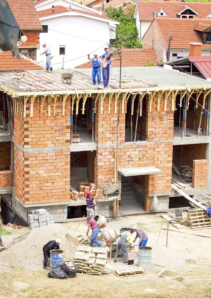 The workers are building a new house in the residential area. Construction site. Real process. — Stock Photo, Image