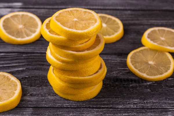 Tahta bir arka planda dilimlenmiş sulu limonlar.