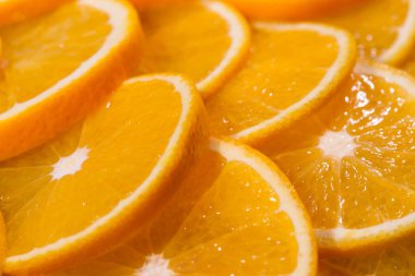 Sulu portakallar dilimlenmiş ve sıraya dizilmiş.