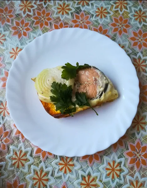 在白盘上放着用酸奶油和鸡蛋调味的洋葱炸红的鱼 — 图库照片