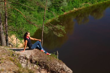 uçurumun tepesinde oturan turist