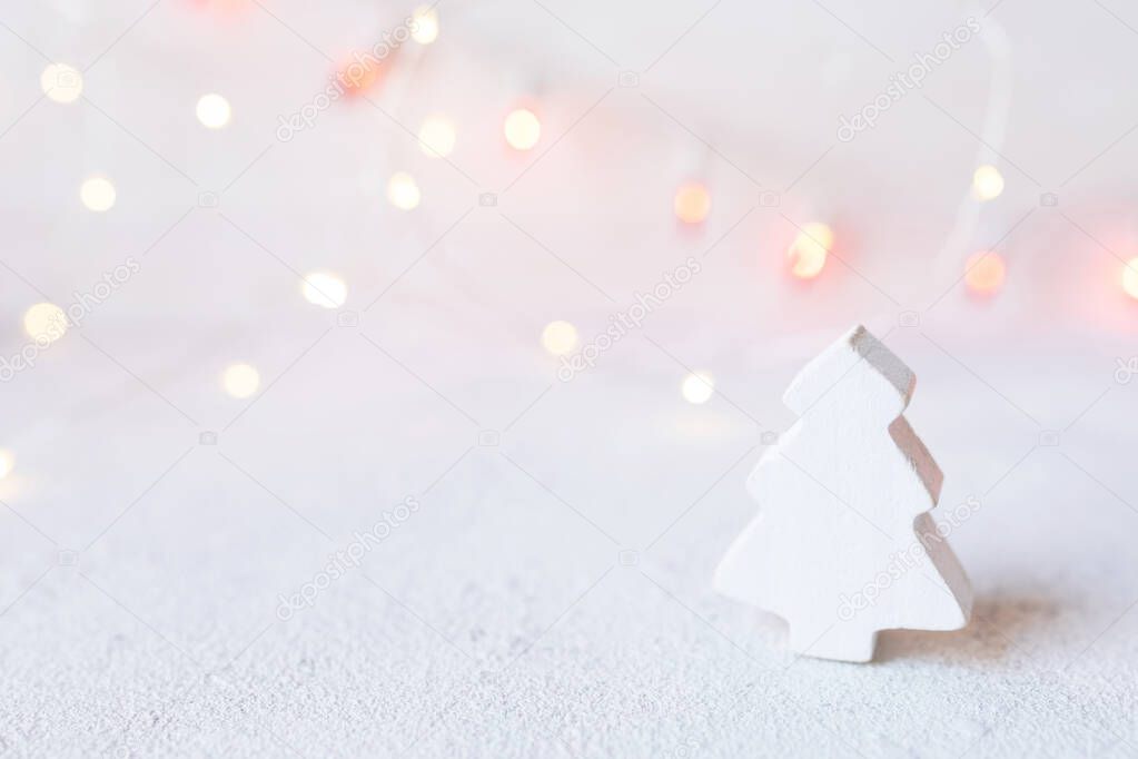 Small white wooden tree on abstract christmas lights background. Greeting card template christmas and New Year with copyspace for text.