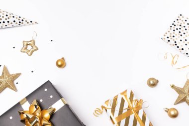 Siyah ve altın süslemeli şık bir Noel kompozisyonu. Hediye ve hediye kutusu, toplar ve yıldızlar beyaz masada. Metin için kopyalama alanı olan bayram hediye kutuları.