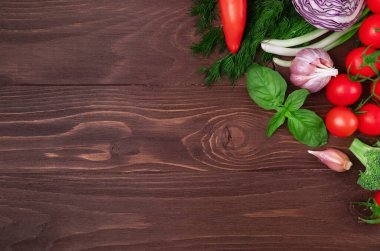 Sağlıklı beslenme düzeni, vejetaryen yiyecekler, beslenme konsepti. Ahşap arka planda salata için çeşitli taze sebzeler, çerçeve. Organik temiz sebzeler. Sağlıklı yaşam tarzı.