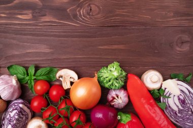 Sağlıklı beslenme düzeni, vejetaryen yiyecekler, beslenme konsepti. Ahşap arka planda salata için çeşitli taze sebzeler, çerçeve. Organik temiz sebzeler. Sağlıklı yaşam tarzı.