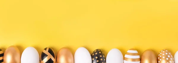 Banner de Pascua - huevos dorados decorados de Pascua están en una fila sobre fondo amarillo. Mínimo concepto de Pascua. Tarjeta de Pascua feliz con espacio de copia. — Foto de Stock