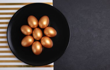 Asgari paskalya konsepti. Siyah tabakta süslü Paskalya yumurtası siyah mermer arka planda izole edilmiş. Paskalya bayramında düzdü. Metin için kopyalama alanı olan Mutlu Paskalyalar kartı.