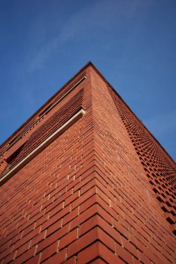 Kırmızı tuğla duvar (binanın köşesi) ve mavi gökyüzü