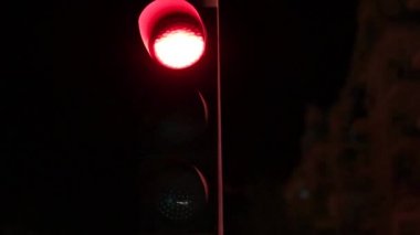 Işığın yavaşça kırmızıdan sarıya, geceleri yeşil ışığa ve arka planda binalara dönüşmesini durdur.