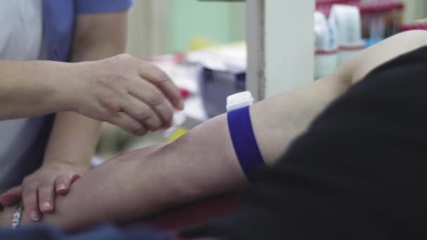 医务工作者和病人在病人的手上寻找静脉 献血绝育手术 视频剪辑