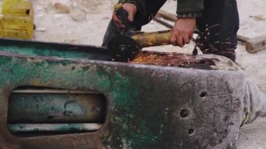 İşyerindeki bir adam tarafından işletilen metal öğütme makinesi. Metal nesneyi kesen güç aracı.