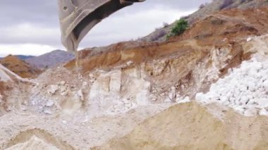 Kazıcı kamyona ağır çekimde kum yüklüyor. İnşaat malzemesi.