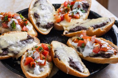 Köstebekler. Vejetaryen Meksika yemekleri bruschetta 'ya benzer. Kızarmış fasulye ve erimiş peynir..