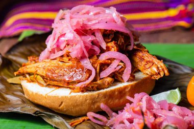 Cochinita Pibil sandviçi, Yucatecan soğan turşusu ve habanero sosuyla servis edilir. Yavaş kavrulmuş domuz sandviçi.