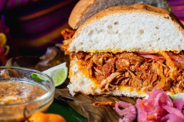 Cochinita Pibil sandviçi, Yucatecan soğan turşusu ve habanero sosuyla servis edilir. Yavaş kavrulmuş domuz sandviçi.