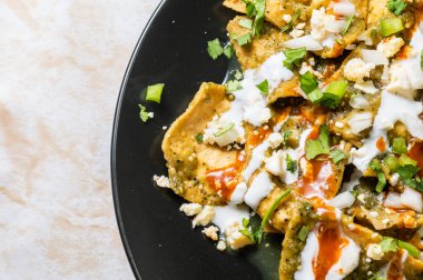 Yeşil Chilaquiles, geleneksel Meksika vejetaryen kahvaltısı kızarmış tortilla ve yeşil sosla kaplanmış